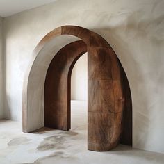 an arch shaped sculpture in the middle of a room with white walls and flooring