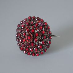 Stunningly beautiful antique red Bohemian garnet pin brooch. Authentic Victorian piece of jewelry from circa 1880's. Over 140 sparkling faceted red garnets are set in 4 consecutive tiers. The gold tone metal setting is a tombak alloy (also known as pinchbeck), which was very popular in the 19-th century. All photos were taken at daylight, the first 2 photos were taken at sunlight, so you can see how the the garnets are sparkling. The brooch will be shipped in a gift box. Garnet is known as the b Antique Red Brooch For Formal Occasions, Antique Red Wedding Brooch, Red Round Brooch Jewelry, Garnet Jewelry Set, Antique Red Brooch Jewelry, Ornate Red Garnet Jewelry, Antique Red Brooch, Antique Red Garnet Necklace, Ornate Red Jewelry Brooch