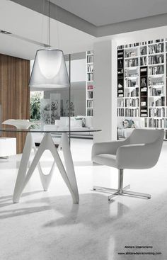 a modern dining room with white chairs and bookshelves in the background, along with a glass table