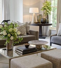 a living room filled with lots of furniture and flowers on top of a coffee table