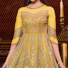 Double your fashion flair as you wear this yellow colored anarkali suit. This net suit is beautifully adorned with embroidered work comes along with santoon silk bottom, heavy japan satin lining and net dupatta which makes it appear more adorning. Women can buy this suit to wear for their upcoming festivals, homely functions, parties, kitties, weekend get together. Get this unstitched suit stitched according to your fit and comfort. Team it with stylish accessories to make your looks more beautiful. Note:- The actual product may differ slightly in color and design from the one illustrated in the images when compared with computer or mobile screen. Size Chart Size: Semi Stitched/Unstitched can be altered from maximum to minimum size based on size chart Gold Anarkali Churidar Floor-length, Gold Anarkali Floor-length Churidar, Yellow Embellished Choli For Eid, Eid Embellished Yellow Choli, Eid Yellow Embellished Choli, Yellow Embellished Sharara For Navratri, Embellished Yellow Sharara For Eid, Yellow Long Sleeve Choli For Wedding, Semi-stitched Yellow Anarkali Set