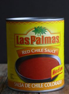 a can of red chili sauce sitting on top of a wooden table