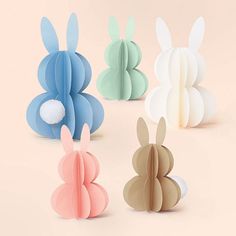 four different colored paper rabbits sitting next to each other