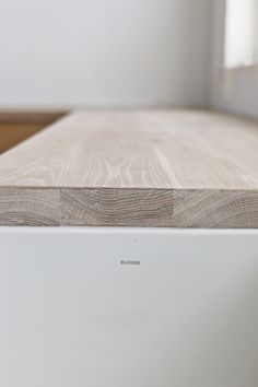 a close up view of the bottom part of a white dishwasher with wood grain on it