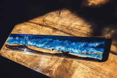 a wooden table topped with a blue and black plate on top of a wooden table