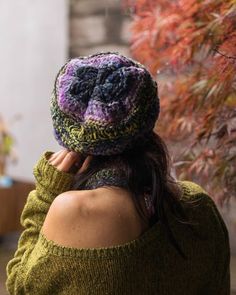 a woman wearing a knitted hat and green sweater