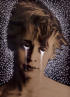 a black and white photo of a woman with tears on her face