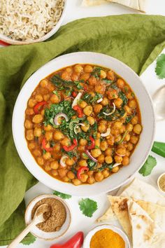 a white bowl filled with chickpeas and spinach next to tortilla chips