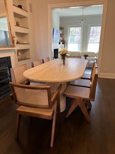 a dining room table with chairs around it and a fireplace in the backround