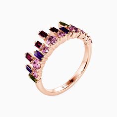 a pink gold ring with purple and green stones on the sides, set against a white background