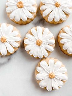 cookies decorated with white flowers on a marble surface