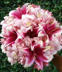 a bouquet of pink flowers sitting on top of a lush green field