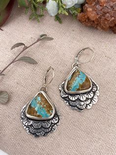 Beautiful Royston Ribbon Turquoise are accentuated by layered feathers with stamped pattern in sterling silver. Shaded patina highlights the design in these unique earrings. Sterling Silver Royston Ribbon Turquoise 1.25” long, 1.” wide Etched Turquoise Sterling Silver Jewelry, Unique Turquoise Patina Earrings, Unique Turquoise Earrings With Patina, Artisan Turquoise Etched Jewelry, Artisan Etched Turquoise Jewelry, Sterling Silver Patina Earrings, Hand Tooled Bohemian Sterling Silver Jewelry, Artisan Hand Tooled Sterling Silver Jewelry, Artisan Hand-tooled Sterling Silver Jewelry