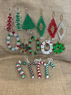 christmas beaded earrings and bracelets are displayed on a cloth covered surface, with the word joy spelled out in small letters