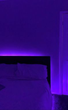 a bed in a room with purple lighting