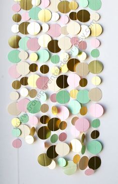 a multicolored paper circle mobile hanging on a wall