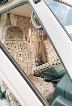 the interior of a white car with crocheted seats