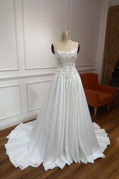 a white wedding dress on display in a room