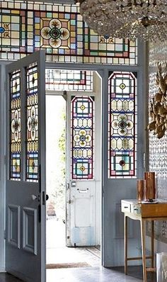 an entryway with stained glass doors and chandelier