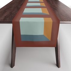 the table is made up of wood and has an abstract design on it, along with a long rectangular dining table