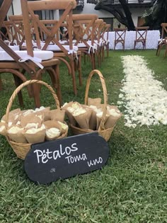 baskets filled with food sitting on top of a grass covered field next to chairs and tables