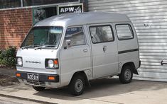 an old van is parked in front of a garage