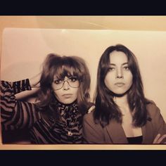 two women with long hair and glasses posing for the camera