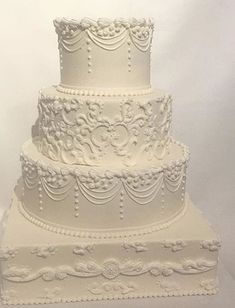 a three tiered white wedding cake on a table