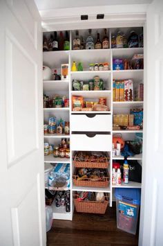 an organized pantry with white shelves and baskets