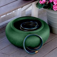 a green chair sitting on top of a wooden floor next to a potted plant