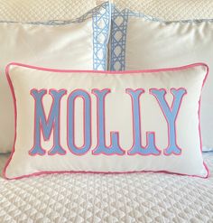 a pillow with the word moly on it sitting on top of a white bed