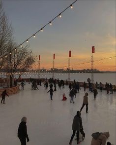 people skating on an ice rink at sunset