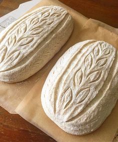 two round breads sitting on top of brown paper