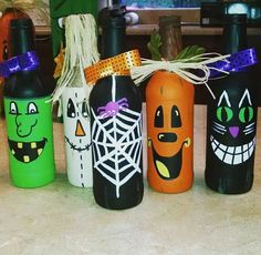 painted wine bottles with faces and pumpkins on them