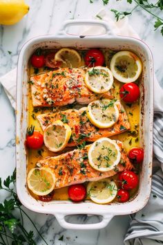 salmon with tomatoes and lemons in a casserole dish