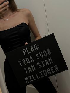 a woman holding a sign that says plan tyda suda tam stam millioner