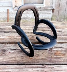 a black sculpture sitting on top of a wooden table next to a barn door and window