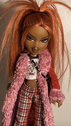 a close up of a doll wearing a pink jacket and plaid pants with long hair