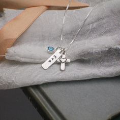 "Personalized Heart Cross Charm Necklace in Silver, Confirmation Cross Necklace, First Communion Cross Necklace, Hand Stamped Jewelry Perfect personalized necklace gift for confirmation or first communion. Sterling silver tag, 3/16\" by 3/4\" lightly hammered and hand stamped with a name or date. Also on the necklace is an adorable cross with a tiny heart attached in the center. To complete the look, a pearl or birthstone of your choice hangs along side the charms. Comes with a sterling silver c Silver Cross Pendant Necklace For Personalized Gift, Silver Cross Pendant Necklace For Birthday, Silver Pendant Necklace For First Communion, Personalized Sterling Silver Cross Charm Necklace, Silver Cross Necklace For Confirmation, Sterling Silver Cross Charm Necklace For Anniversary, Personalized Cross Necklaces For Anniversary, Personalized Cross Necklaces For Wedding, Silver Engraved Necklace For First Communion