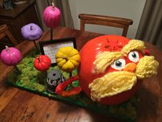 a fake tomato sitting on top of a wooden table next to other fake fruits and vegetables