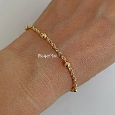 "Thank you for coming in! Genuine 14K SOLID YELLOW GOLD bracelet with 6 ball/bead stations and a spring ring clasp. THEY ARE STAMPED WITH \"585\", but we could not show it clearly in the pictures. Made in Italy! Super cute! You'll get a 7 inch bracelet per winning! We also have 18 inch and 16 inch necklace options in our shop! DIMENSION: 2.2mm rope width, 4mm spheres, 5mm spring ring clasp. WEIGHT: 2 gram MATERIAL: 14K Yellow Gold" Gold-plated Chain Bracelet With Gold Beads, Gold Ball Chain Bracelet Gift, Gold Adjustable Ball Chain Bracelet, Gold Plated Chain Bracelet With Gold Beads, Gold Beaded Chain Rosary Bracelet With Round Beads, Gold Rosary Bracelet With Beaded Chain, Gold Ball Chain Bracelet For Everyday, Everyday Gold Ball Chain Beaded Bracelets, Everyday Gold Beaded Bracelets With Ball Chain