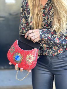 a woman holding a red purse in her right hand