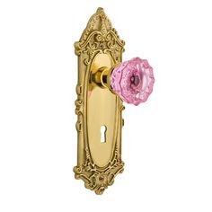 a pink and gold door handle with a flower on it