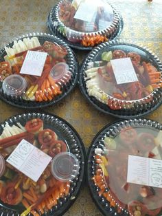 four plastic plates filled with food on top of a table