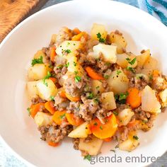 a white plate topped with potatoes and meat