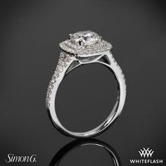 a white gold engagement ring with diamonds on the sides and an oval center stone in the middle