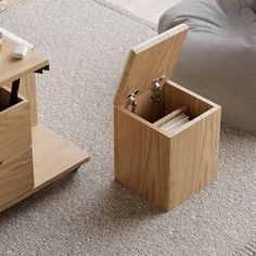 an open wooden box sitting on top of a carpeted floor next to a bed