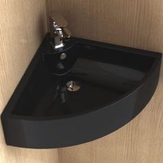 a black sink mounted to the side of a wooden wall