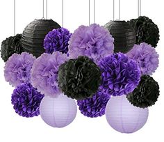 purple and black paper flowers are hanging from the ceiling in front of a white background