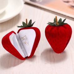 two red strawberry shaped objects sitting on top of a table